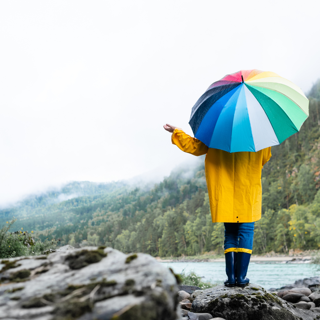 A kid standing in the rain with a colourful umbrella - Weather depends on where you live